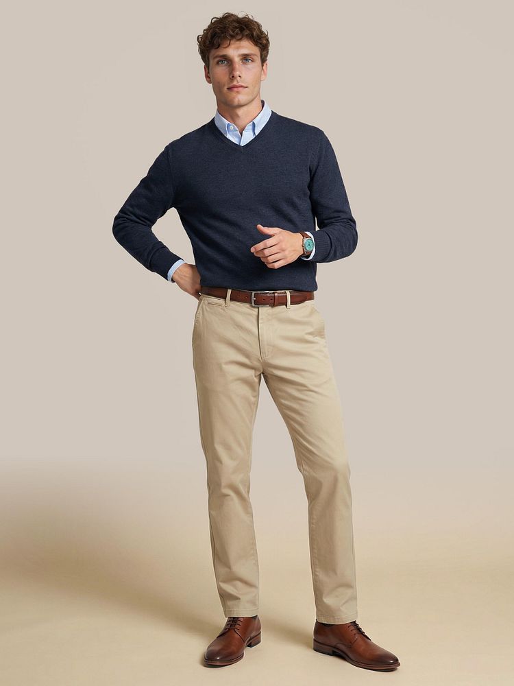 Chino newbury beige met Leren herenschoen donkercognac, Overhemd Oxford lichtblauw, Pullover v-hals merinowol donkerblauw en Riem structuur leer bruin